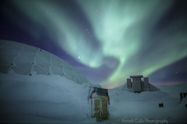 Aurora above the old Dome Station at the South Pole before it was removed.