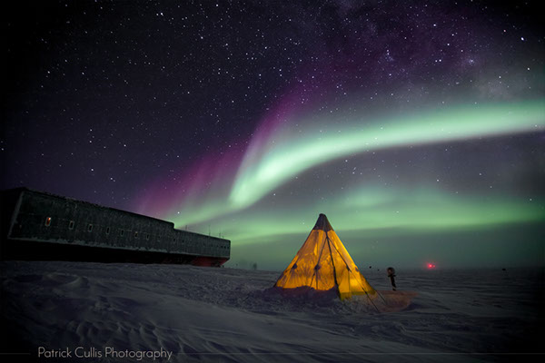 Aurora shine above a Scott Tent set up in front of the Amundsen-Scott South Pole Station, Antarctica.