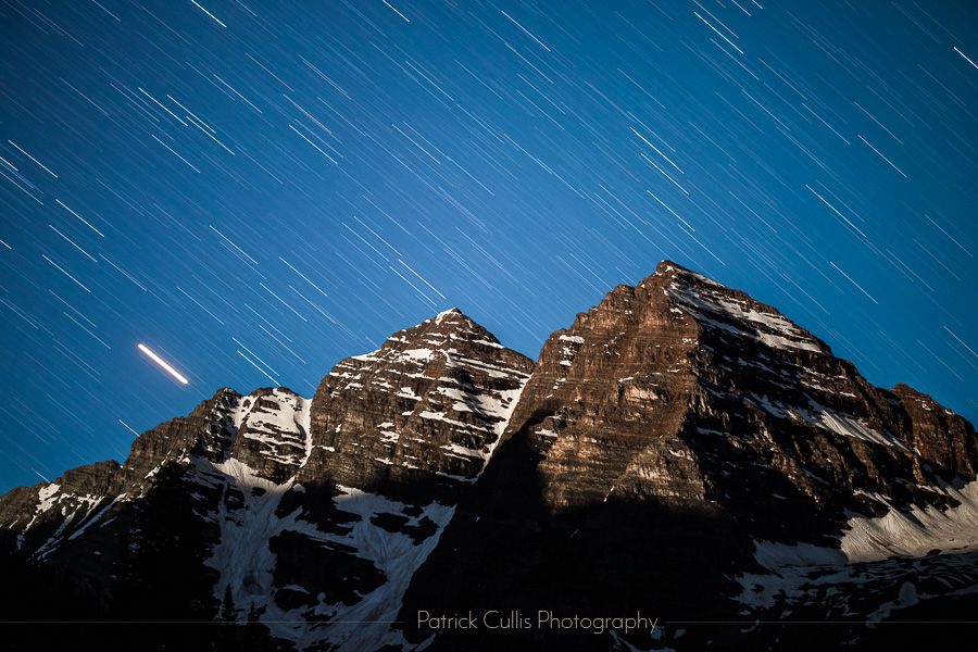 Star streaks behind the Maroon Bells as moonrise illuminates the peaks by Patrick Cullis